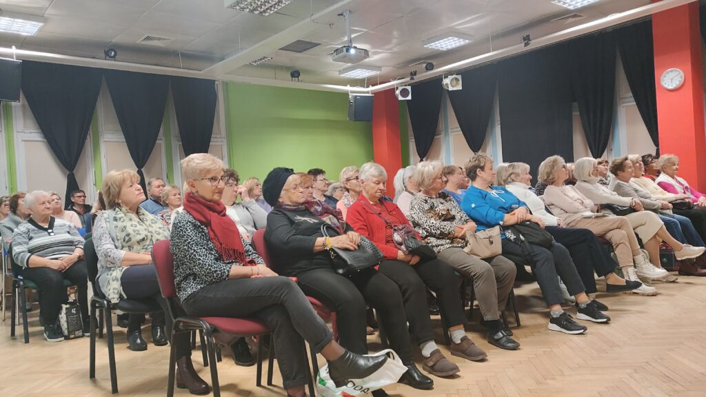 zdjęcie przedstawia seniorów słuchających wykładu