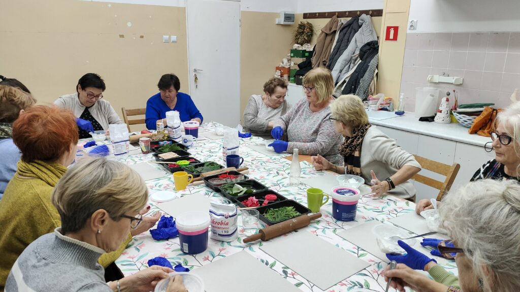 zdjęcie przedstawia grupę kobiet pracujących przy stole na warsztatach