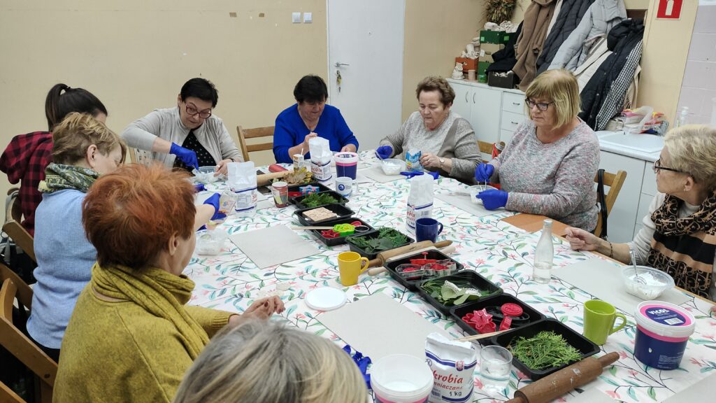 zdjęcie przedstawia grupę kobiet pracujących przy stole na warsztatach