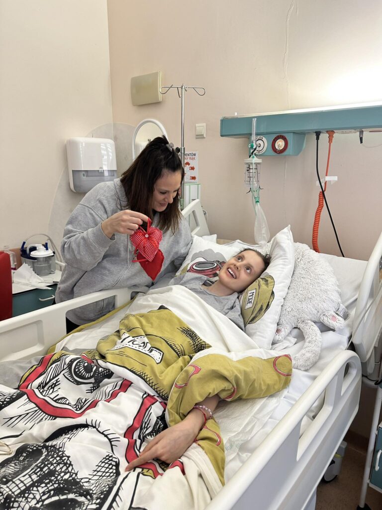seniorzy przekazują dzieciom w szpitalach uszyte serduszka z okazji Walentynek