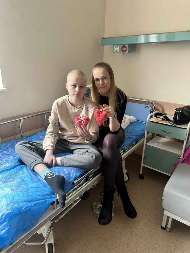 seniorzy przekazują dzieciom w szpitalach uszyte serduszka z okazji Walentynek