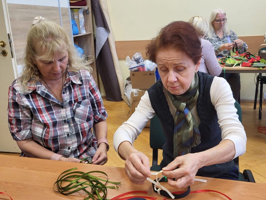 seniorzy biorą udział w warsztatach szycia strojów na przedstawienie taneczne dla dzieci