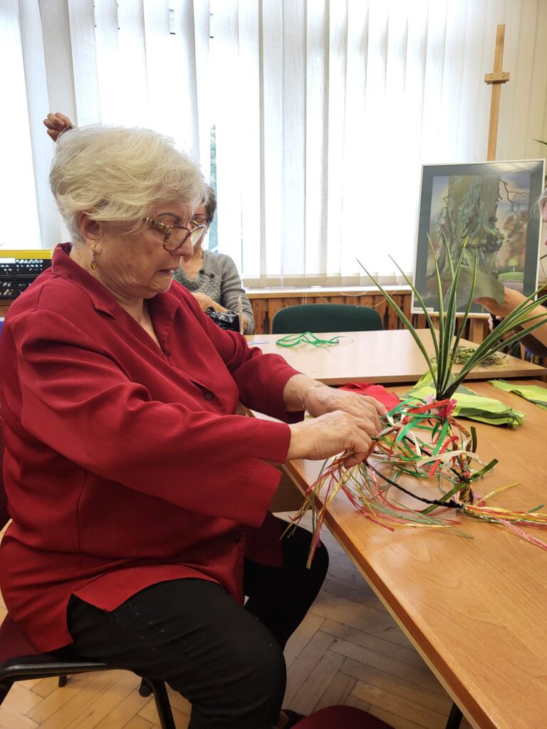 seniorzy biorą udział w warsztatach szycia strojów na przedstawienie taneczne dla dzieci