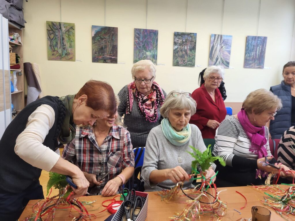 seniorzy biorą udział w warsztatach szycia strojów na przedstawienie taneczne dla dzieci