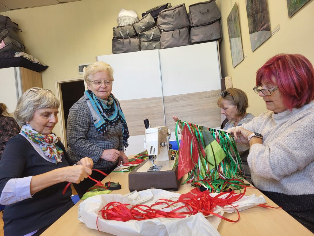 seniorzy szyją stroje i rekwizyty do przedstawienia tanecznego dla dzieci