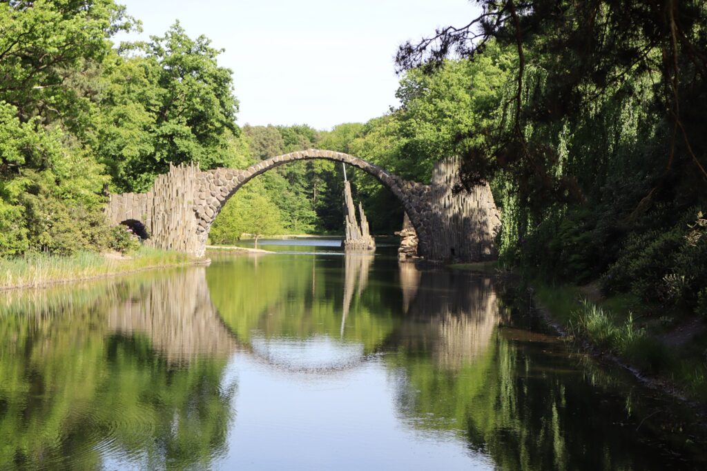 Zdjęcie przedstawia sztucznie utworzone jezioro w Parku Rododendronów i Azalii w Kromlau w Niemczech