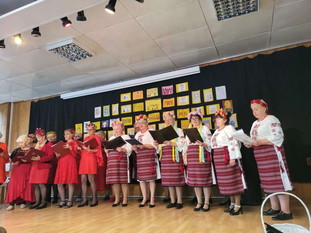 Zdjęcie przedstawia uczestniczki koncertu „Dla Ciebie, Mamo!” w klubie "Dąb": seniorki z Kapeli Dębowej i panie z grupy "Ukraiński Wianuszek"