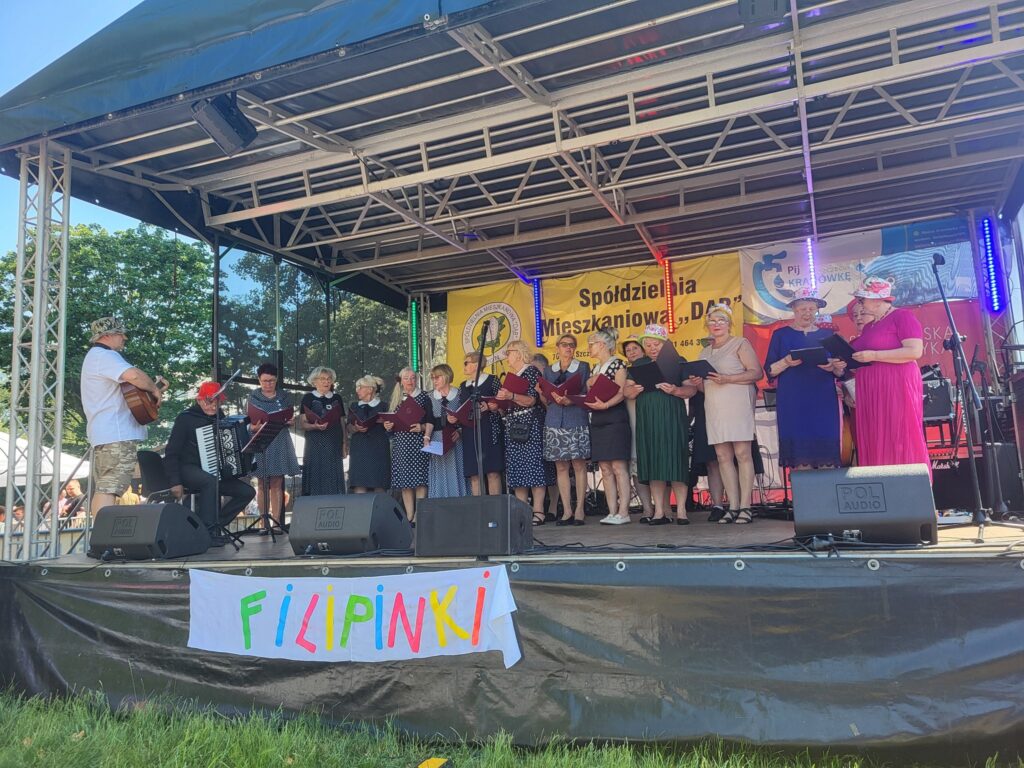 zdjęcie przedstawia uczestników imprezy plenerowej "Powitanie lata" na osiedlu Słonecznym