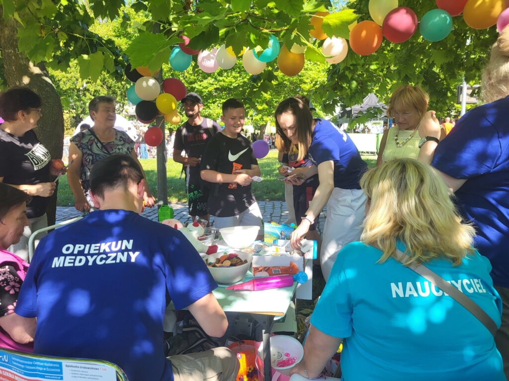 zdjęcie przedstawia uczestników imprezy plenerowej "Powitanie lata" na osiedlu Słonecznym