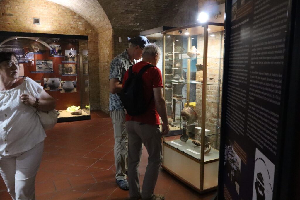 zdjęcie przedstawia uczestników wycieczki zwiedzających z lokalną przewodniczką Muzeum Twierdzy Kostrzyn