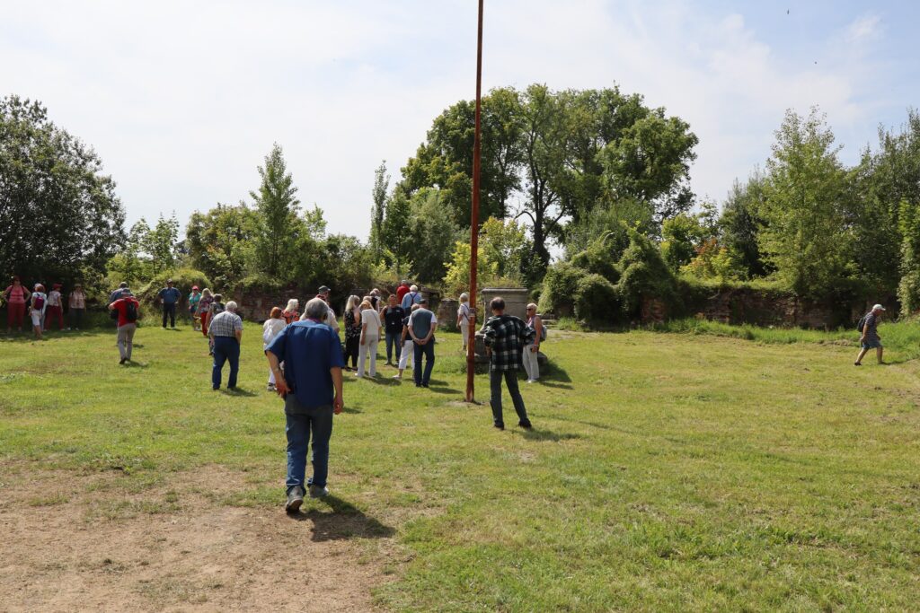 zdjęcie przedstawia uczestników wycieczki zwiedzających z lokalną przewodniczką Muzeum Twierdzy Kostrzyn