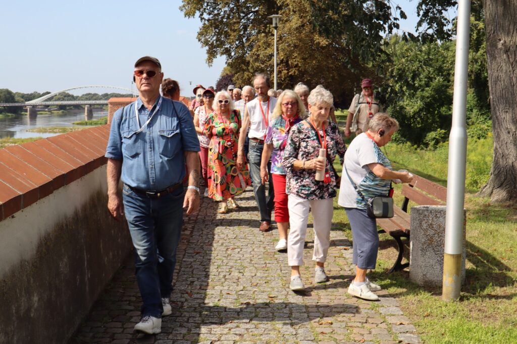 zdjęcie przedstawia uczestników wycieczki zwiedzających z lokalną przewodniczką Muzeum Twierdzy Kostrzyn