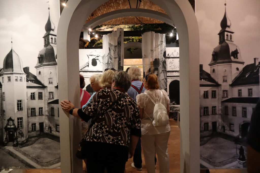 zdjęcie przedstawia uczestników wycieczki zwiedzających z lokalną przewodniczką Muzeum Twierdzy Kostrzyn