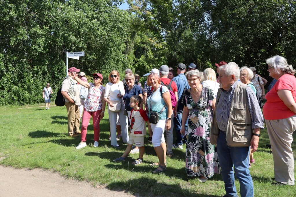 zdjęcie przedstawia uczestników wycieczki zwiedzających z lokalną przewodniczką Muzeum Twierdzy Kostrzyn
