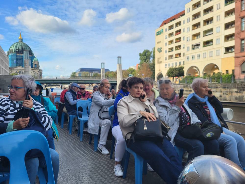 zdjęcie przedstawia seniorów w zwiedzających Berlin podczas rejsu po Szprewie