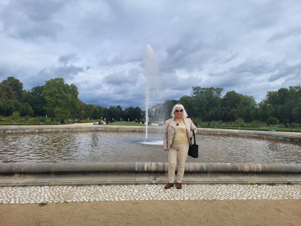 zdjęcie przedstawia seniorkę w ogrodzie przy pałacu Charlottenburg