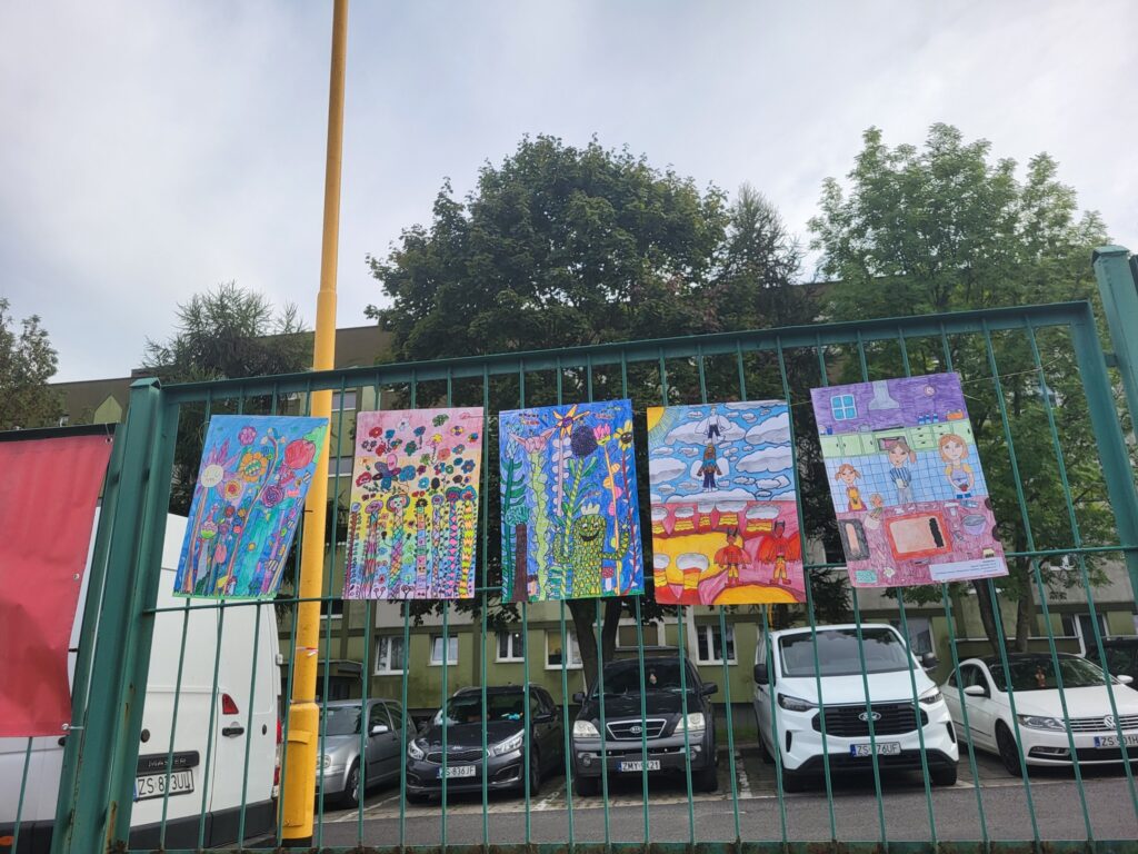 zdjęcie przedstawia wystawę prac plastycznych podczas imprezy plenerowej "Pożegnanie lata" na osiedlu Bukowym