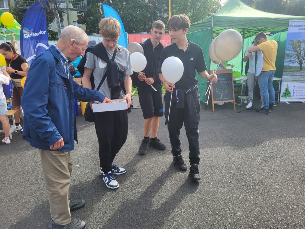 zdjęcie przedstawia uczestników imprezy plenerowej "Pożegnanie lata" na osiedlu Bukowym