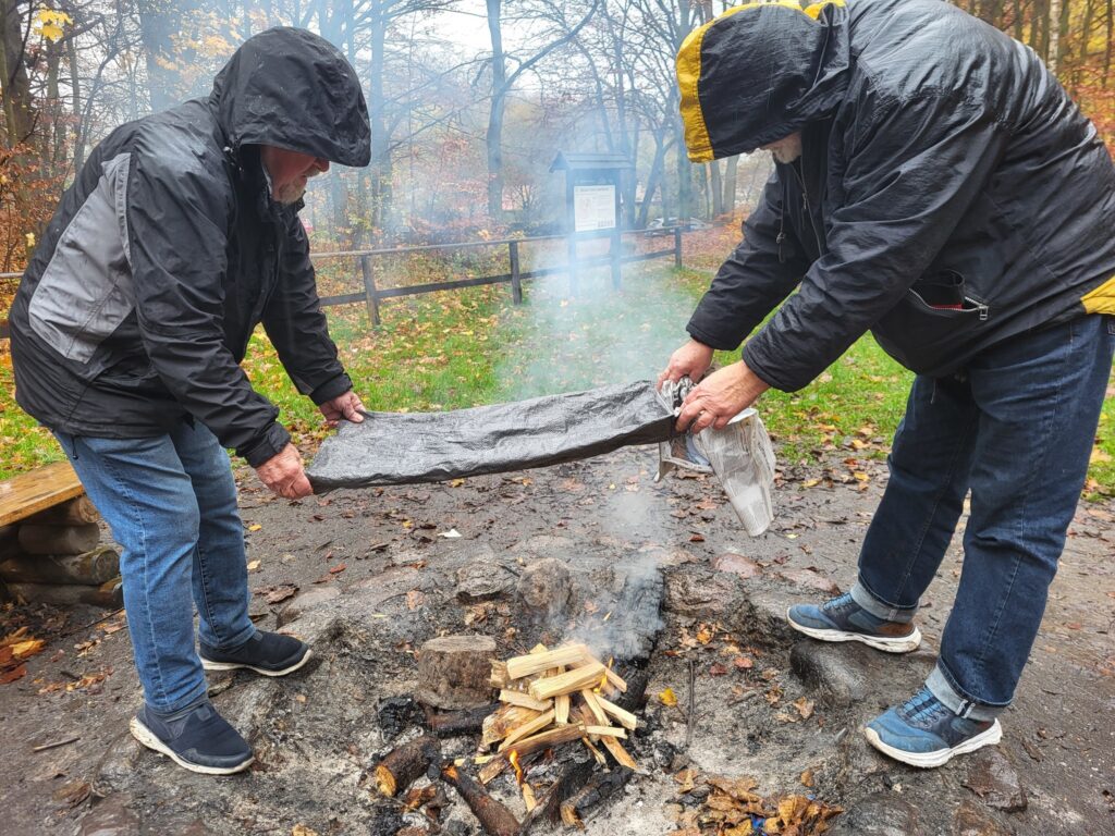 zdjęcie przedstawia uczestników obchodów Święta Niepodległości z Klubu Seniora "Dąb" - mimo niepogody