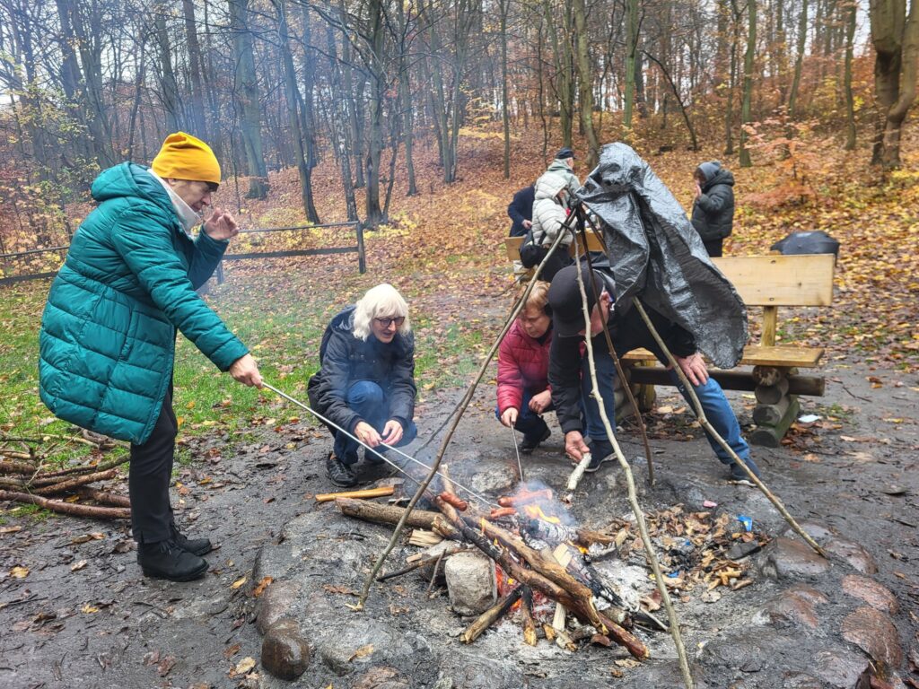 zdjęcie przedstawia uczestników obchodów Święta Niepodległości z Klubu Seniora "Dąb" - mimo niepogody