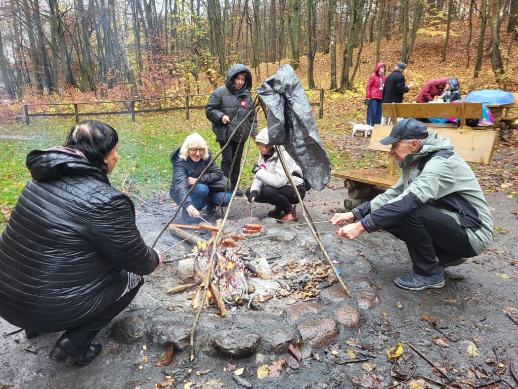 zdjęcie przedstawia uczestników obchodów Święta Niepodległości z Klubu Seniora "Dąb" - mimo niepogody