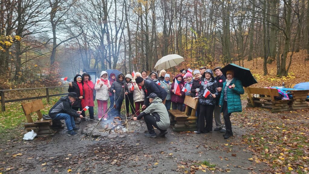 zdjęcie przedstawia uczestników obchodów Święta Niepodległości z Klubu Seniora "Dąb" - mimo niepogody