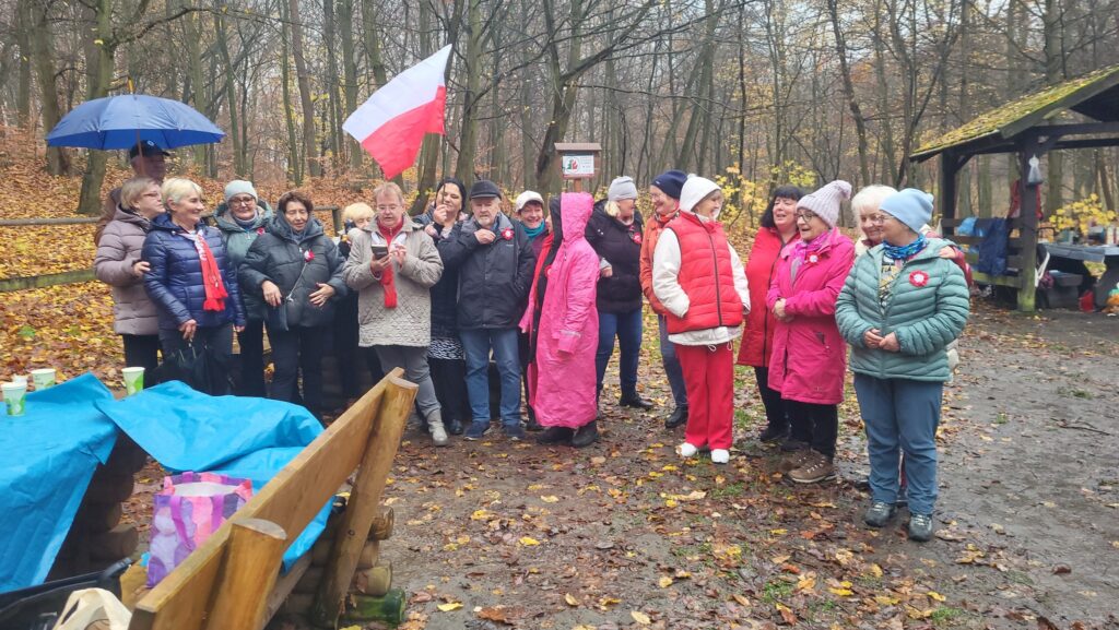 zdjęcie przedstawia uczestników obchodów Święta Niepodległości z Klubu Seniora "Dąb" - mimo niepogody